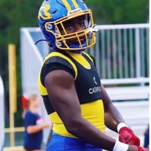 High school football player in pads on the sideline