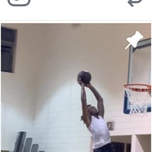 Basketball player finishing a dunk in a gym